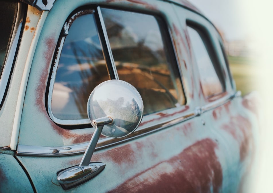 Old junk car parked in a yard in Calgary to be towed by Calgary Scrap Auto Removal Junk Car Removal Service.